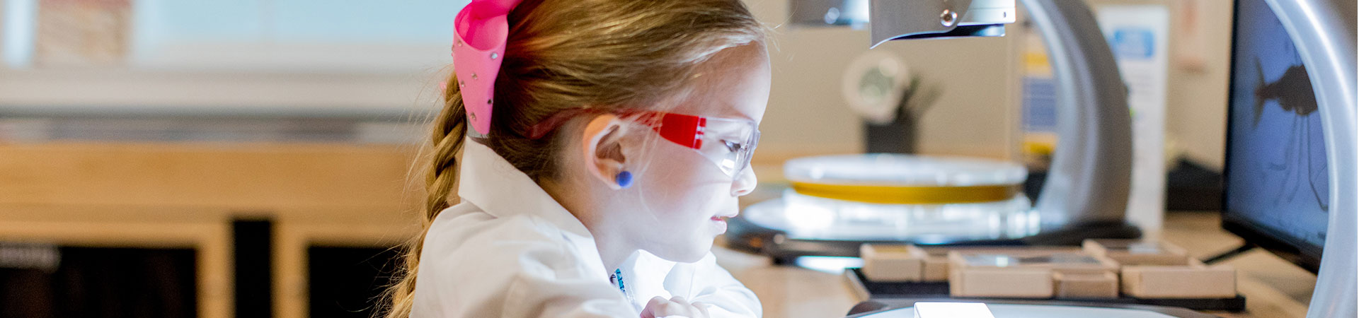  girl scout in science lab looking at microscope 